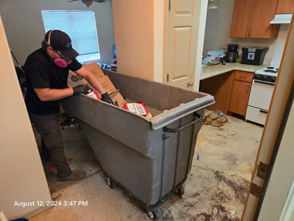 A pest control expert removing trash and debris from a home